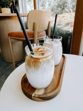 Nefis bardaklarda servis edilen nefis buzlu kahve rahat bir kafede ahşap bir tepside.