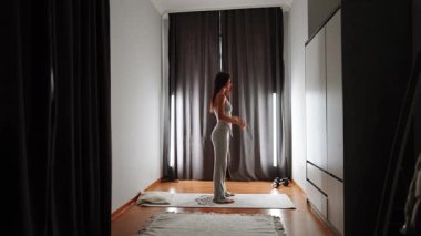 Doğal ışık ve sakinleştirici atmosferi olan sakin bir yatak odasında sabah yoga pratiği.