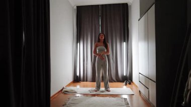 Kapalı bir alanda dinamik yoga seansı. Doğal ışık içeri giriyor.