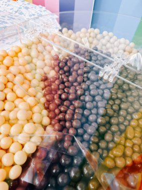 Bir çok farklı tonda çikolata kaplı şekerlemeler içeren renkli şeker sergisi