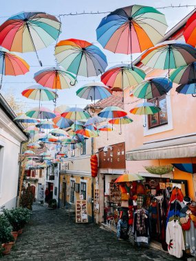 Güneşli bir günde tarihi bir köyde renkli şemsiyeler dekore edilir.
