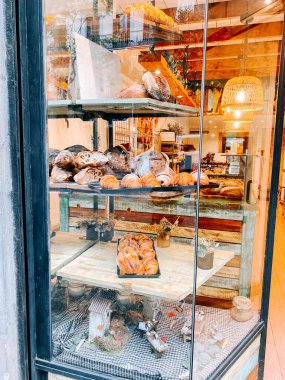 Canlı bir mahallede sıcak bir fırın vitrininde taze pişmiş yiyecekler sergileniyor.