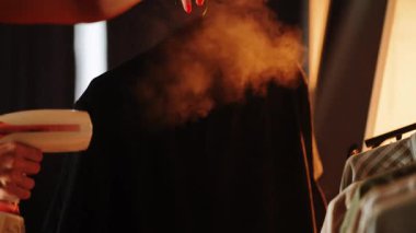 Konforlu bir ev ortamında giysi buharlı bir gömlek ütülemek.