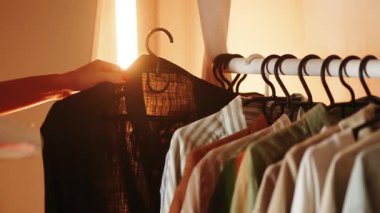 Akşam üstü evinde ütü yapmak için buharlı kıyafet kullanan bir kadın.