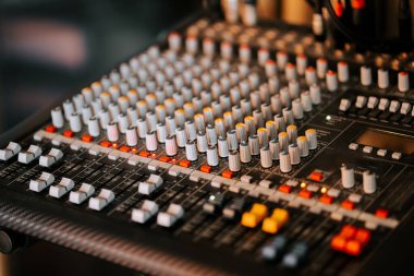 Profesyonel bir kayıt stüdyosunda ışıklı düğmeler ve faders ile karıştırma konsolu