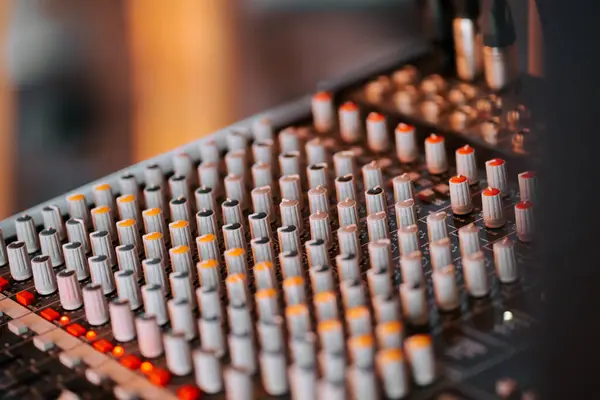 Bir müzik seansı sırasında kayıt stüdyosunda sayısız düğme ve ayarlarla konsolu karıştırmak