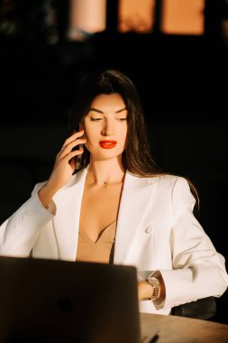 Zarif bir ofis ortamında geç saatlere kadar çalışırken bir telefon konuşmasına dahil olan model