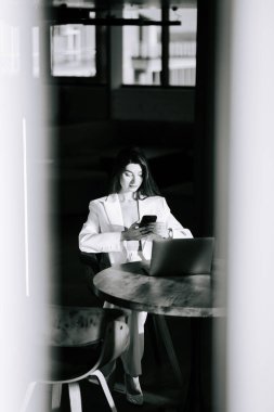 Modern ofis ortamında çalışan ve iletişim kuran profesyonel bir kadın.