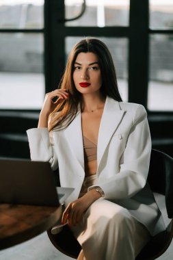 Gündüz vakti modern ofis ortamında profesyonel bir kadın güven içinde poz veriyor