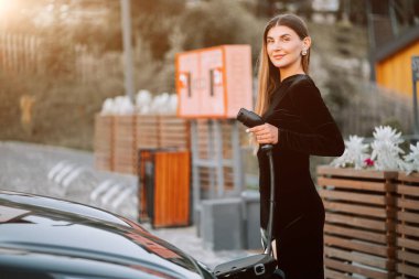 Gün batımında sakin bir ortamda benzin alan bir kadın.