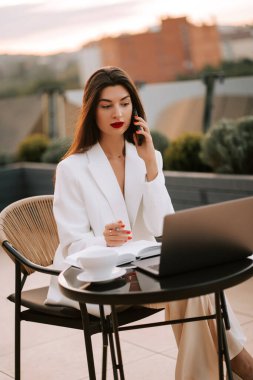 İş kadını, gün batımında dışarıda çalışırken konferans çağrısında bulundu.