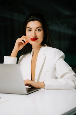 Modern çalışma saatlerinde dizüstü bilgisayarda çalışan profesyonel bir kadın.