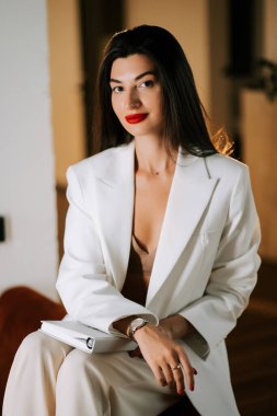 Şık bir kadın rahat bir iç mekan ortamında şık bir şekilde poz verir.