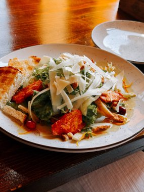 Taze salata, ızgara tavuk, sebze ve sıcacık bir restoranda servis edilen tost.