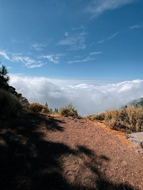 Gün ortası güneşli ortamda, dağların zirvesinden nefes kesici bir manzara.