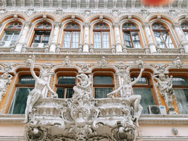 Aydınlık bir günde şehir merkezindeki tarihi bir binanın karmaşık mimari detayları.