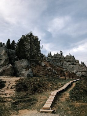 Yol kayalık araziye çıkıyor. Bulutlu gökyüzünün altında, sakin açık havada.