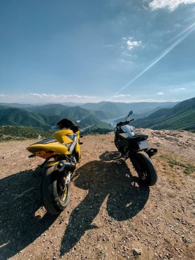 Doğada güneşli bir günde dağda park etmiş motosikletler.