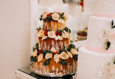 Çiçekler ve böğürtlenlerle süslenmiş güzel dekore edilmiş üç katlı pasta.