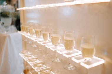 Lüks bir mekandaki bir kutlama etkinliğinde arka plandaki rafta sergilenen zarif içkiler.