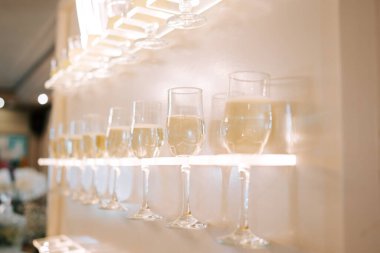 Modern bir rafta, şık bir mekanda, ışıl ışıl içeceklerle dolu kadehler.