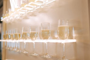 Kutlama sırasında hafif ışıklandırma altında yakılan şampanya kadehlerinin zarif bir gösterisi.