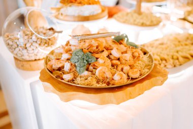 Karides ve erişteli lezzetli deniz ürünleri yemeği şenlikli bir aşçılık toplantısında servis ediliyor.