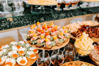 Şık bir mekânda düzenlenen şenlikli bir toplantıda gurme aperatifleri sunan zarif bir büfe.