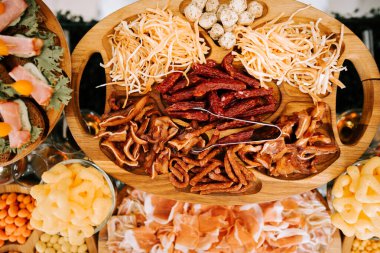 Şenlikli bir toplantıda çeşitli et ve peynirlerle şarküteri tabağı.