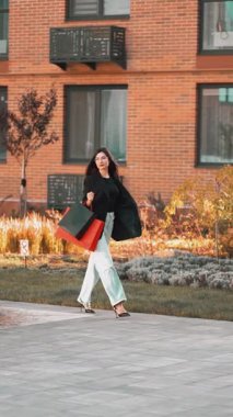 Şehirde alışveriş günü, çantalar taşıyan şık bir kadınla.