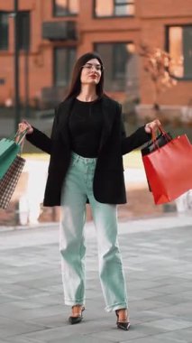 Modern bir şehirde alışveriş yapan şık bir kadın.