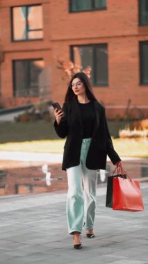 Modern bir açık hava ortamında mesajları kontrol ederken alışverişin tadını çıkarıyorum.