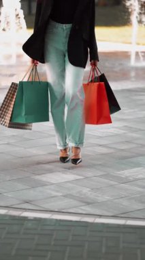 Plazada güneşli bir öğleden sonra renkli çantalarla alışveriş günü.