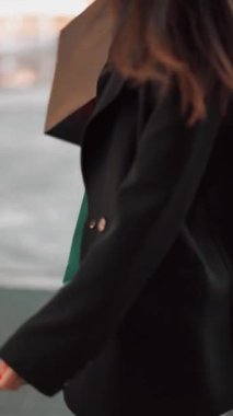 Güneşli bir öğleden sonra moda mağazasını keşfederken alışveriş torbaları elinde.