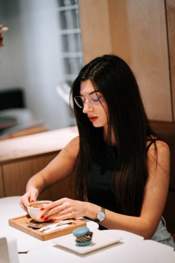 Sıcak bir kafede kahve ve tatlıyla sakin bir anın tadını çıkarıyorum.