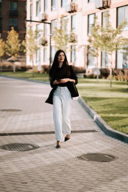 Young woman walks along a modern pathway in a serene urban environment during the evening