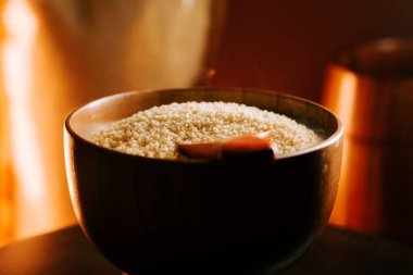 Tahta bir kasede pişmemiş kuskus, doğal ışık ve sıcak tonlarda.