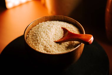 Kuskus ahşap bir kasede, servis kaşığı da pişirmeye hazır.