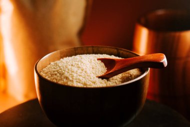 Tahta kasede kuskus, kaşık ile sıcak, desenli arka plan.