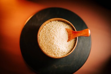 Kasede kuskus, tahta kaşıkla karanlık bir yüzeyde pişmeye hazır.