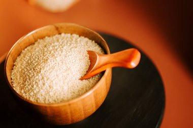 Tahta bir kasede kuskus ve pişirmeye hazır bir kaşık.