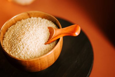 Tahta bir kasede kuskus ve lezzetli bir yemek hazırlamak için bir kaşık.