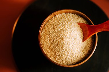 Tahta bir kâsede kuskus, ahşap bir kaşıkla yemek pişirmeye ya da yemek hazırlamaya hazır.