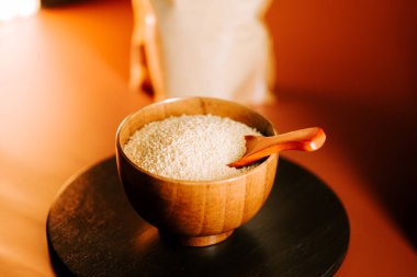 Ahşap bir kepçe ile ahşap bir kasede sergilenen basit pişmemiş kuskus.