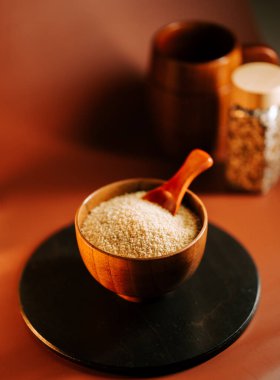 Tahta bir kasede kuskus ve siyah bir yüzey.