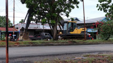 Bengkulu, Endonezya. Mart 2023: Yürüyen merdivenler, Hibrida Raya Caddesi 'nde tamir edilmek üzere hasarlı asfalt kazıyor.           