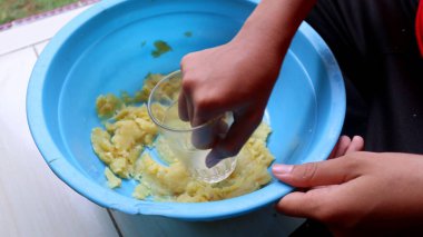 Endonezya usulü patates keki yapma süreci. Patatesler cam kullanılarak eziliyor.                         