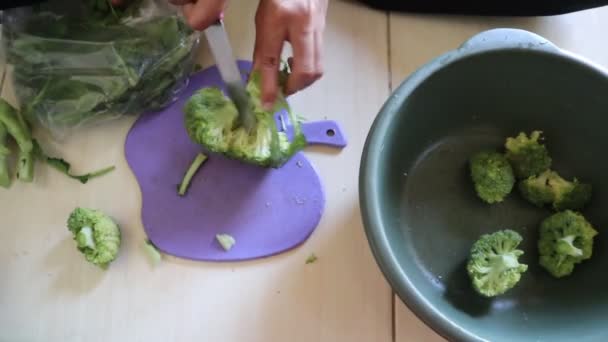Asyalı Genç Kız Bıçakla Kesme Tahtasıyla Brokoli Doğruyor — Stok video