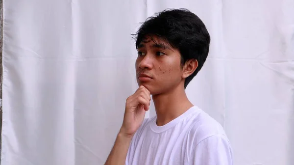 Asiático Hombre Blanco Camiseta Pensando Sosteniendo Barbilla Con Mano —  Fotos de Stock