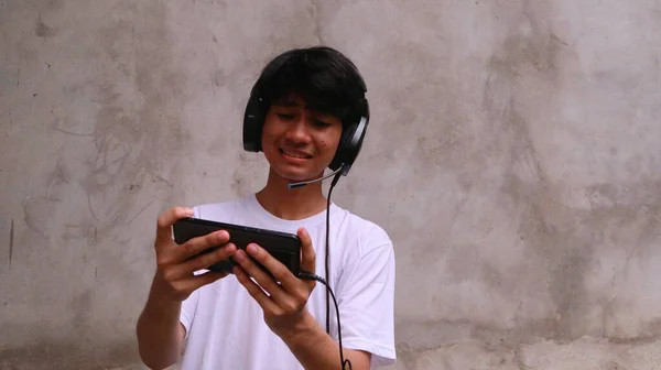 アジア人男性はスマートフォンを使ってゲームをしています — ストック写真